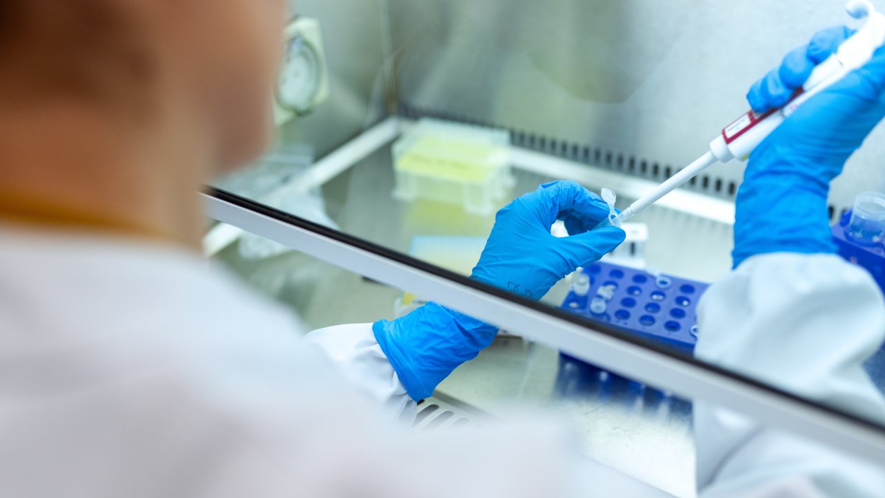 Foto de pesquisador mexendo com equipamentos de laboratório