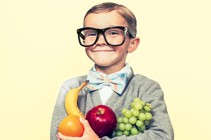 foto de criança de óculos com frutas no colo
