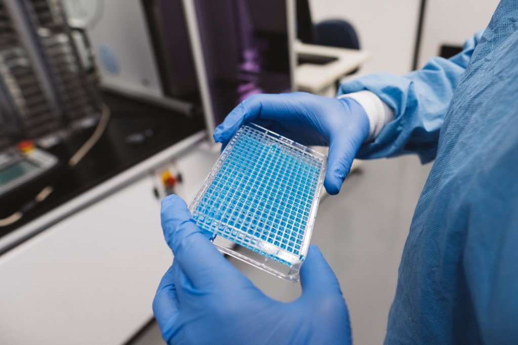 Foto de cientista segurando placa para realização de exames