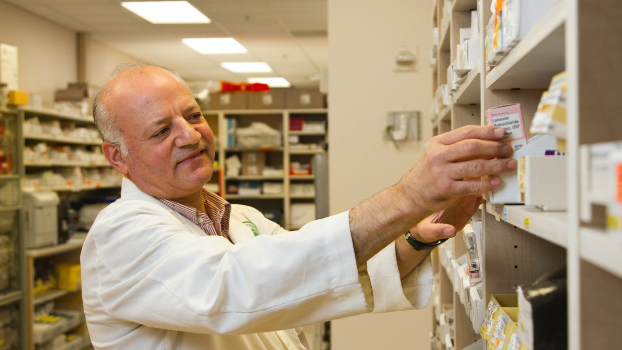 foto de farmacêutico pegando caixa de medicamento